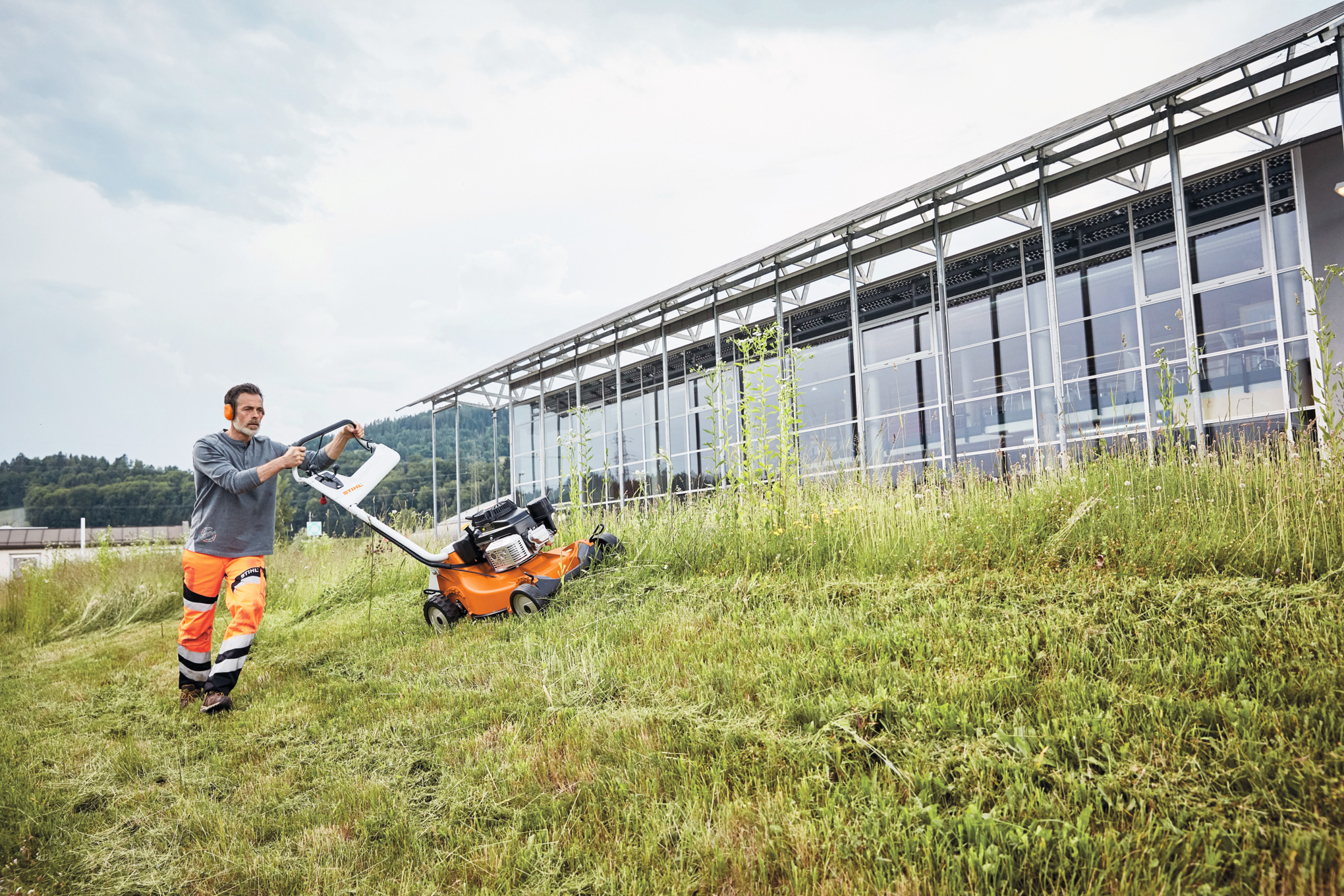 Een man maait een helling met een STIHL RM 756 GC benzinegrasmaaier 