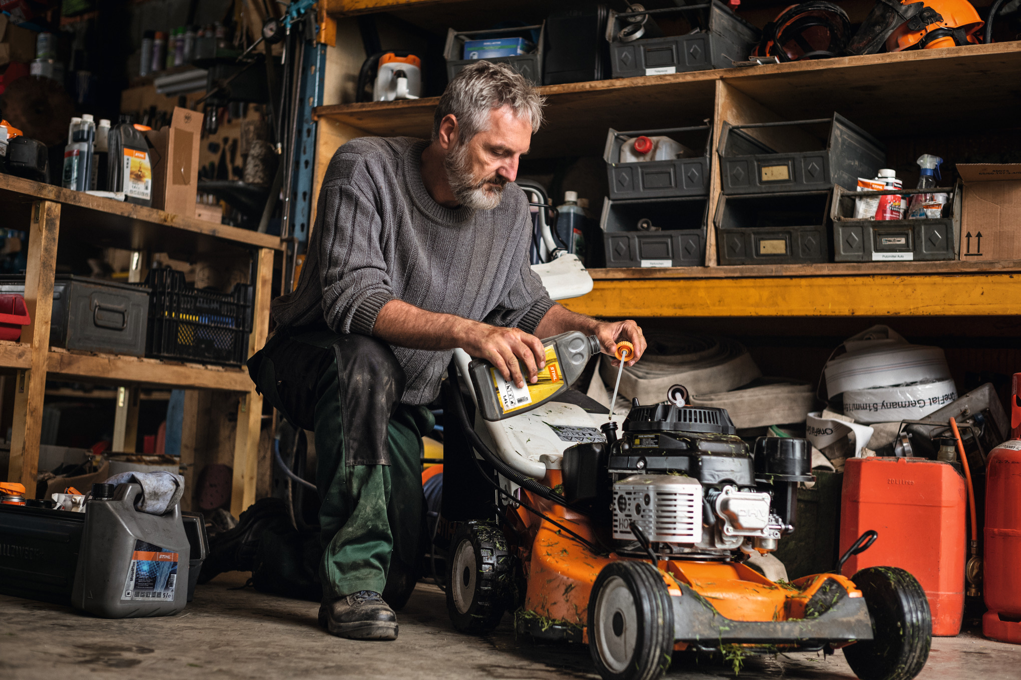 Man onderhoudt zijn STIHL RM 756 benzinegrasmaaier in de garage