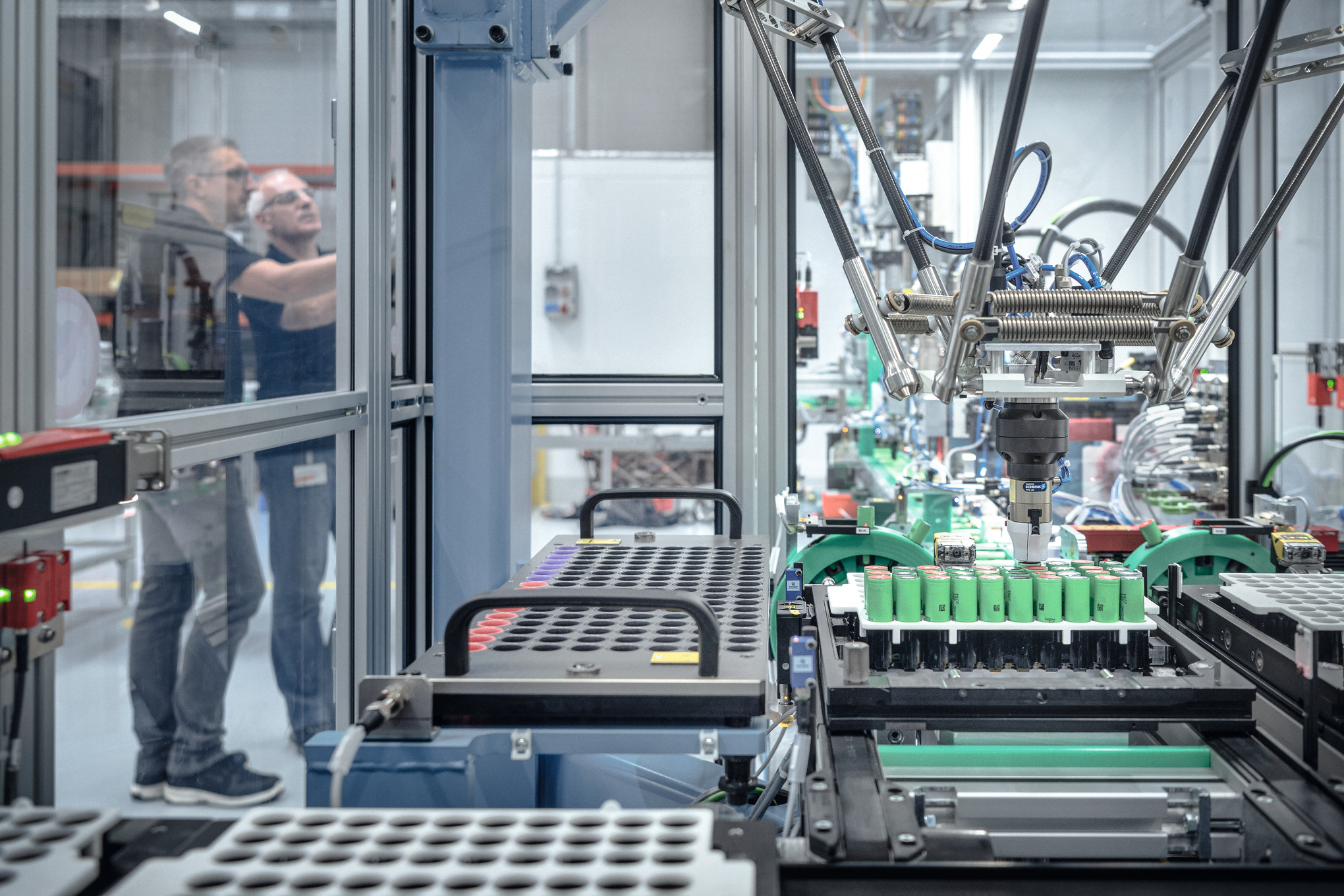 Twee mannen in de accuproductie van STIHL omringd door machines en robots