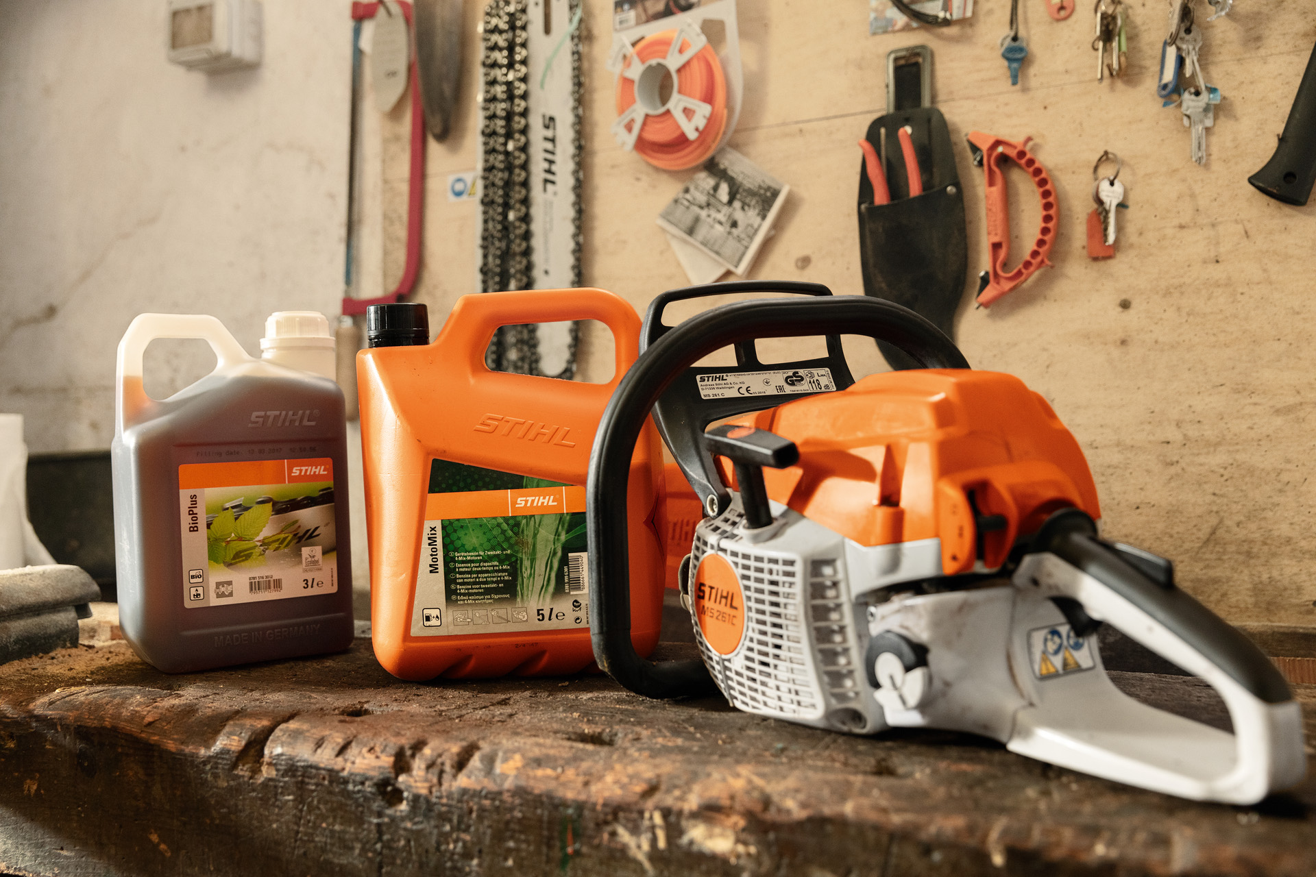 STIHL benzinekettingzaag MS 261 C-BE met gereedschapsloze tankdop naast MotoMix en BioPlus