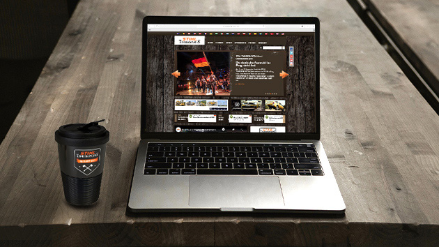 Laptop met de TIMBERSPORTS® website open en een kop TIMBERSPORTS® koffietas