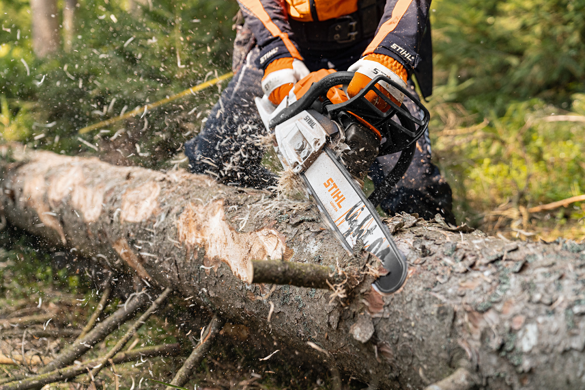 Een stam wordt met de STIHL benzinekettingzaag MS 261 C-M met 2-MIX-motor en zaagblad Light 04 in het bos ontschorst