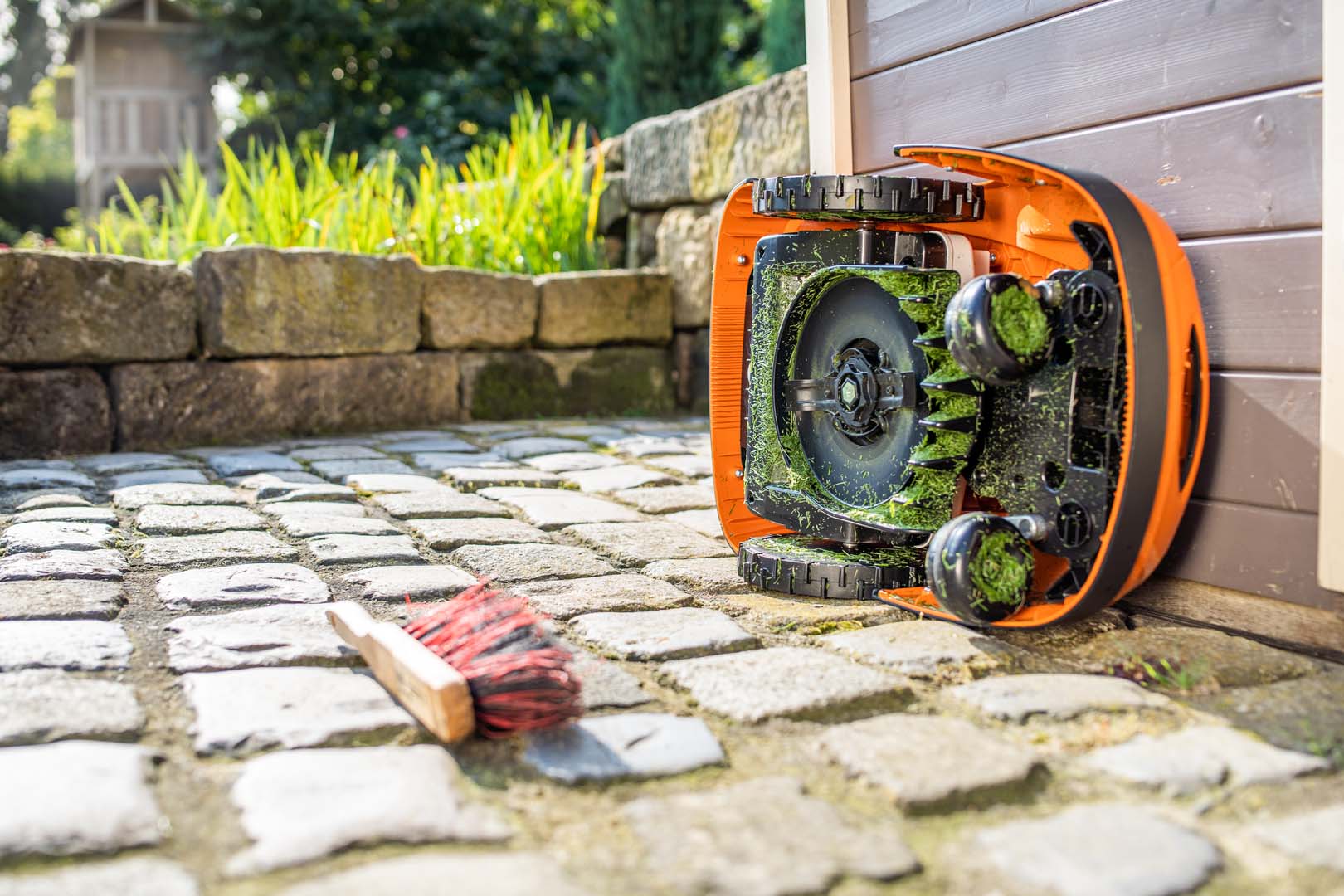 STIHL iMOW® robotmaaier op zijn zij gekanteld, vóór reiniging