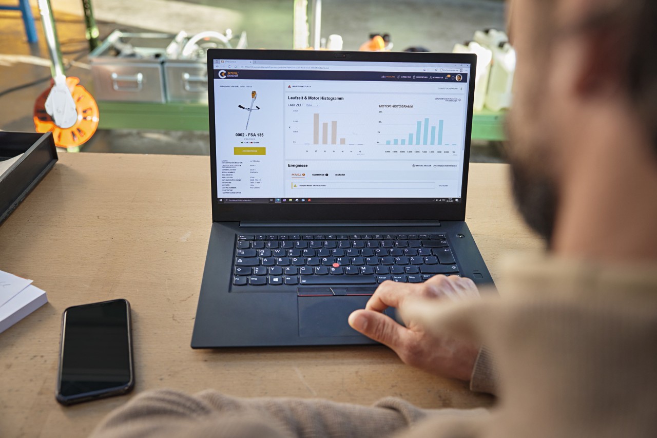 Iemand gebruikt het STIHL connected Portal op een laptop en bekijkt daar verschillende machinegegevens. 