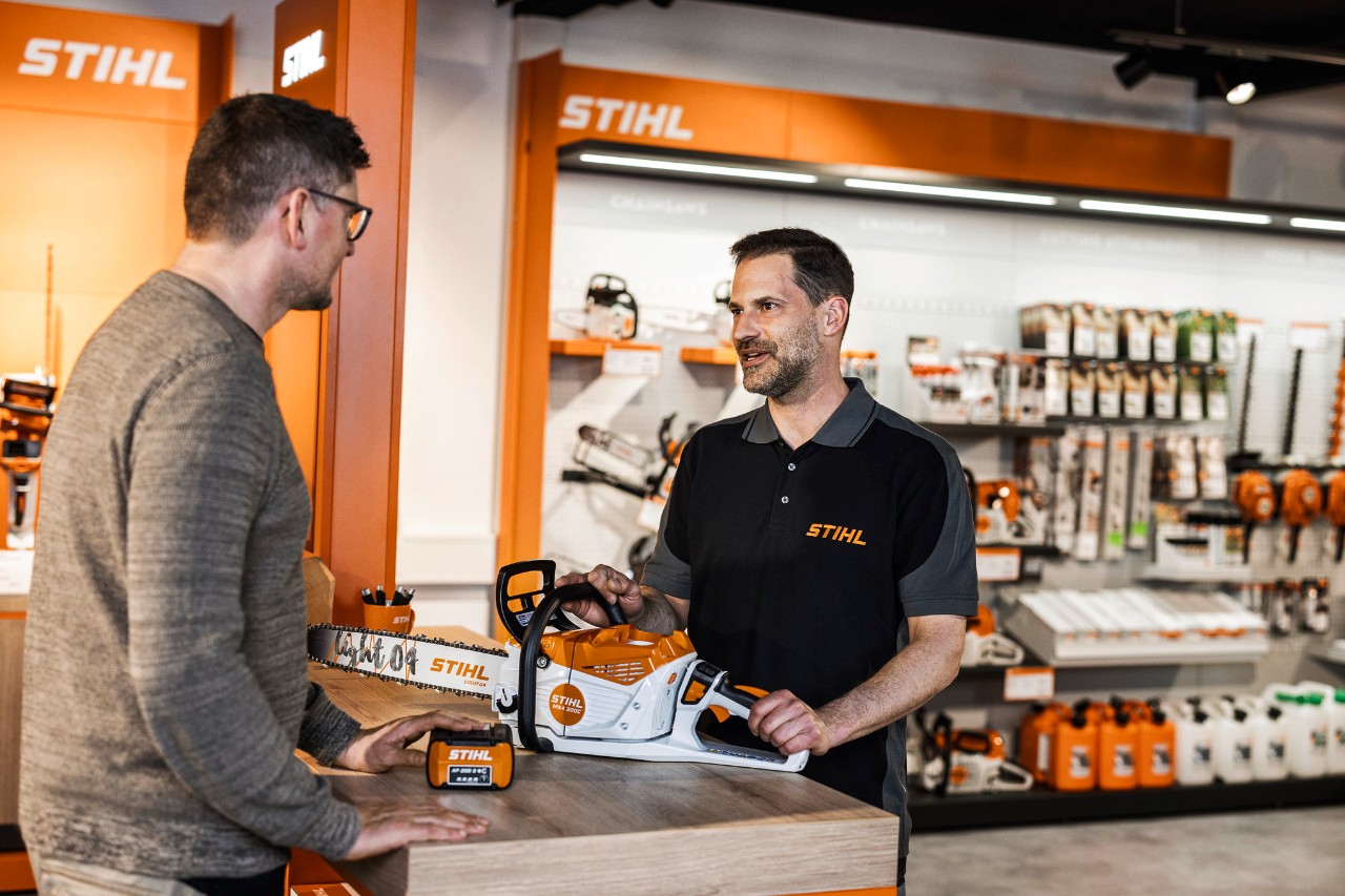 De STIHL dealer adviseert zijn klanten in zijn showroom over de STIHL accukettingzaag MSA 300