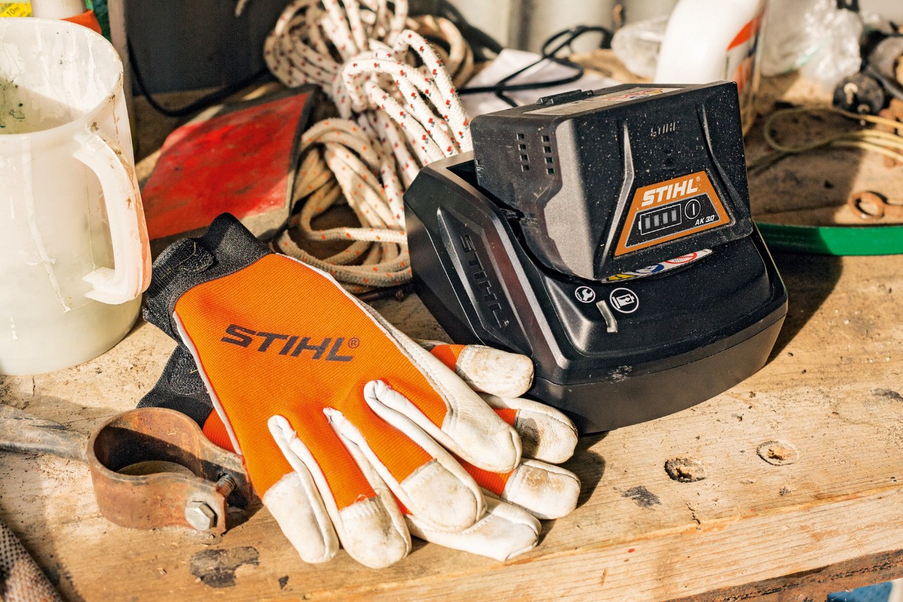 Accu en handschoenen liggen op een werkoppervlak